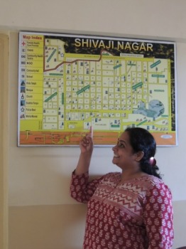 Shweta points to a map of the Shivaji Nagar slum community, where she works to empower young women and girls.