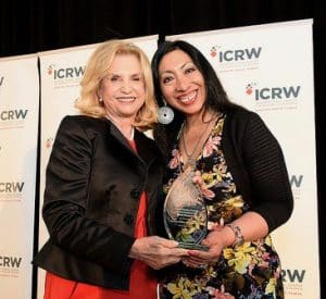 two women posing with an award